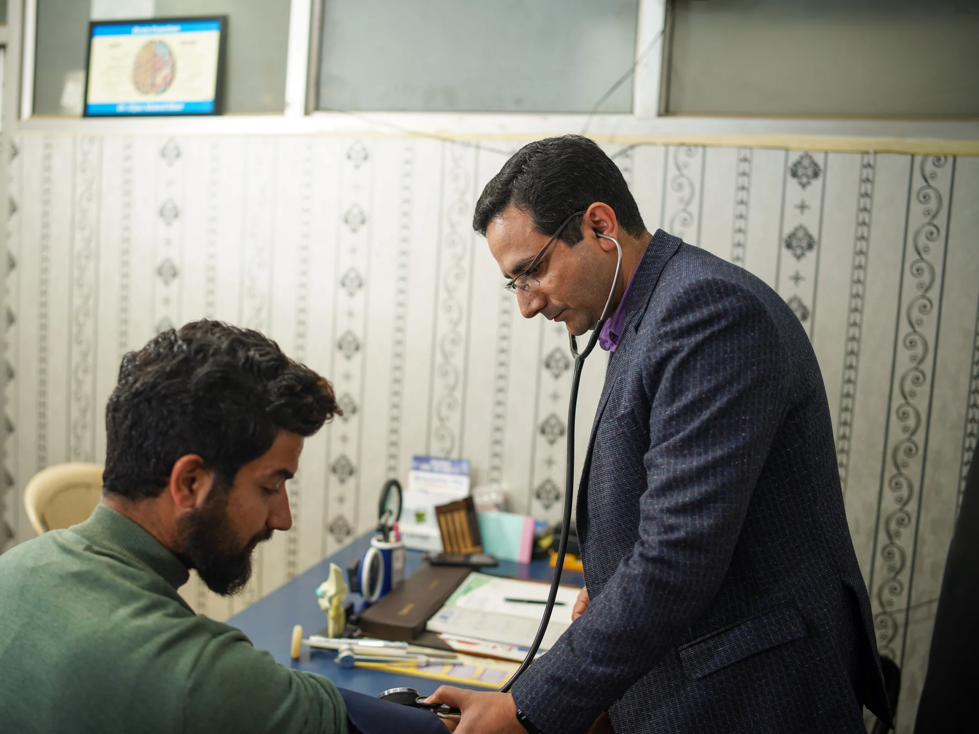 Doctor examining a patient at the consultation desk in the out-patient department